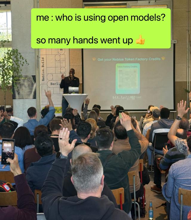 Audience members raising their hands during Sujee's talk in Berlin